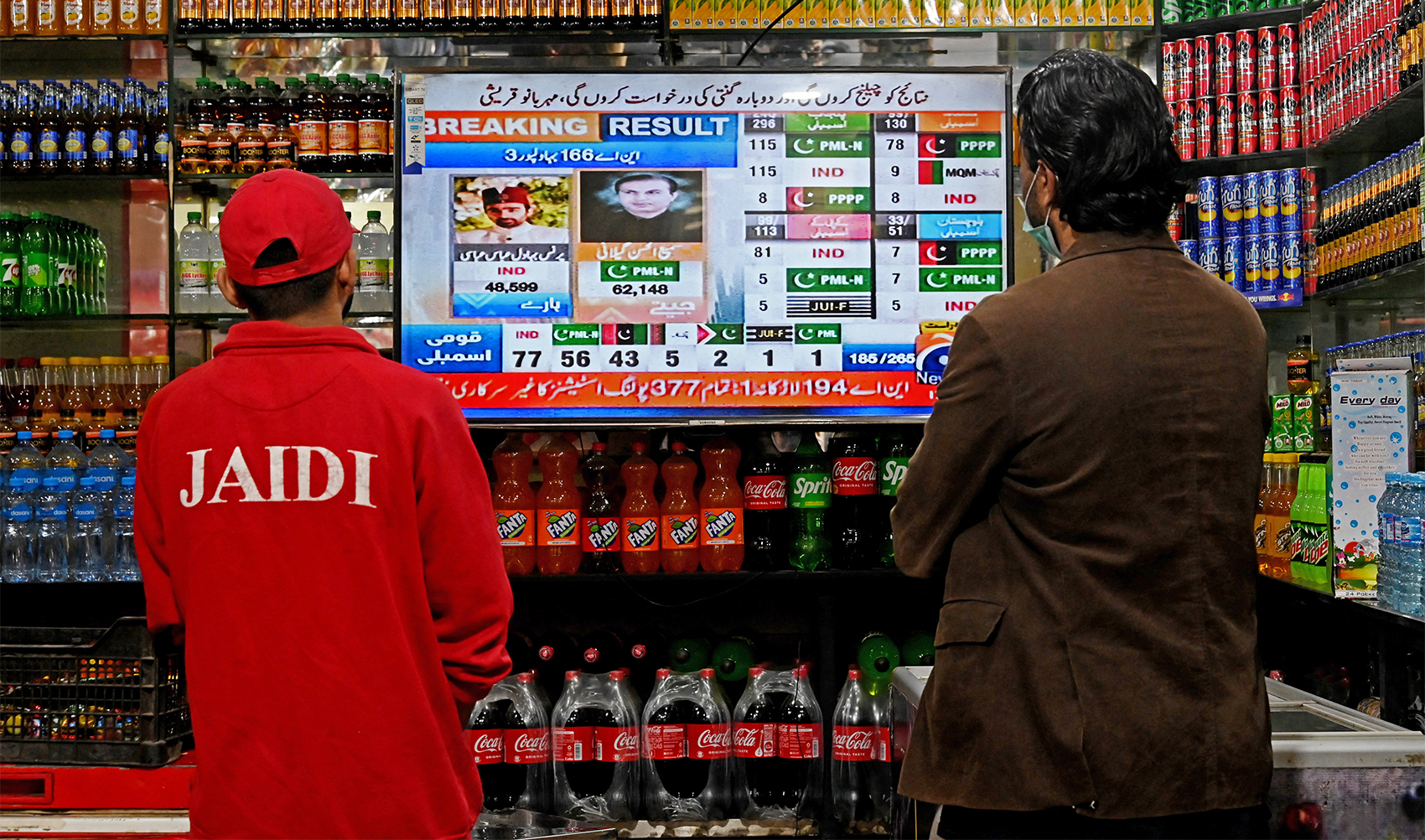 People watch latest election results live on a television at a shop, a day after Pakistan's national elections in Lahore on February 9, 2024. (AFP/File)