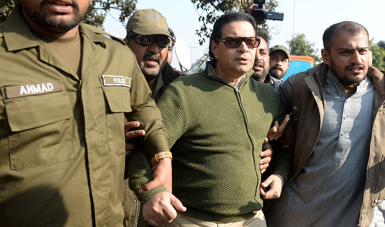 Policemen detain Salman Akram Raja (C), a candidate of Khan's Pakistan Tehreek-e-Insaf (PTI) party at a protest against the alleged skewing in Pakistan's national election results, in Lahore on February 17, 2024. (AFP)
