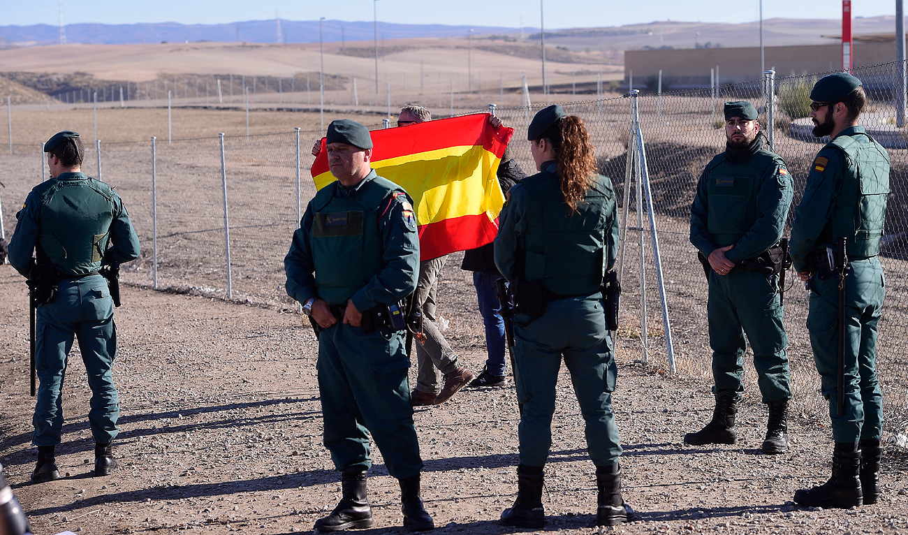 In this file photo, taken on December 19, 2017, Spanish Guardia Civils stand guard as a man holds a Spanish flag during a demonstration in front of the Estremera prison in Madrid. (AFP/File)