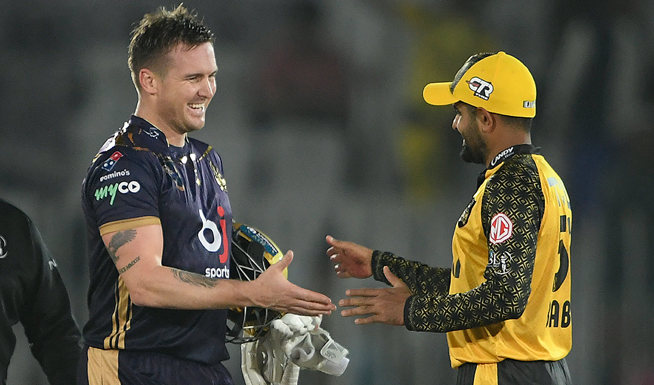 Quetta Gladiators' Canadian Jason Roy (L) shakes hands with Peshawar Zalmi's Pakistani captain Babar Azam after winning the Pakistan Super League (PSL) T20 cricket match between Quetta Gladiators and Peshawar Zalmi at the Rawalpindi Cricket Stadium, in Rawalpindi on March 8, 2023. (AFP/File)