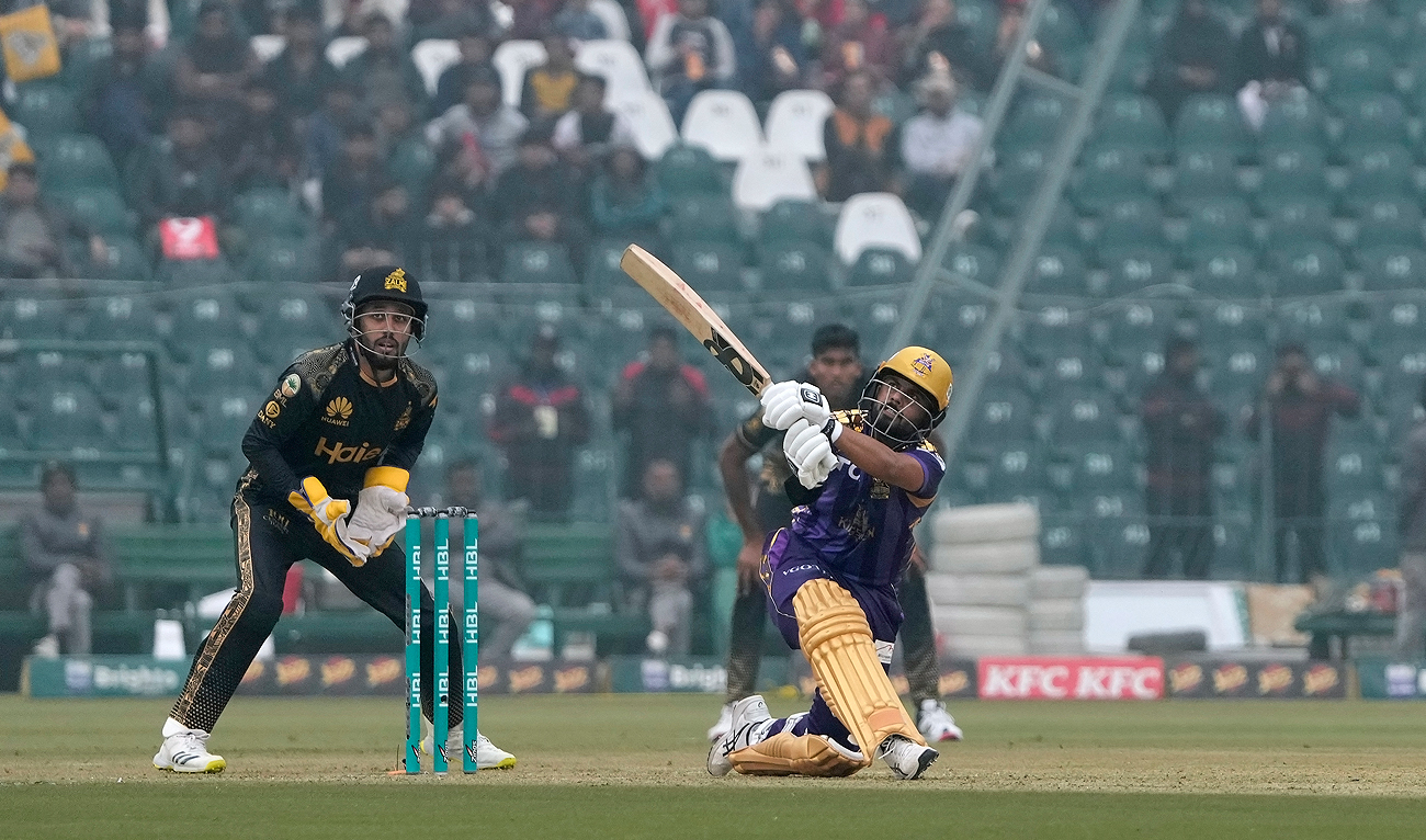 Quetta Gladiators' Saud Shakeel, right, plays a shot for six as Peshawar Zalmi' Mohammad Haris watches during the Pakistan Super League T20 cricket match between Quetta Gladiators and Peshawar Zalmi, in Lahore on February 18, 2024. (AP)