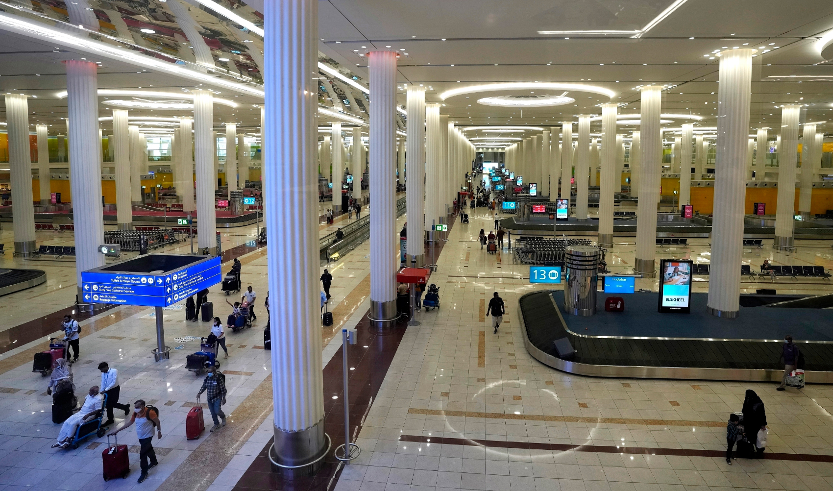 Passengers leave the baggage handling hall at the Dubai International Airport terminal 3, in Dubai, United Arab Emirates, on October 25, 2022. (AP)
