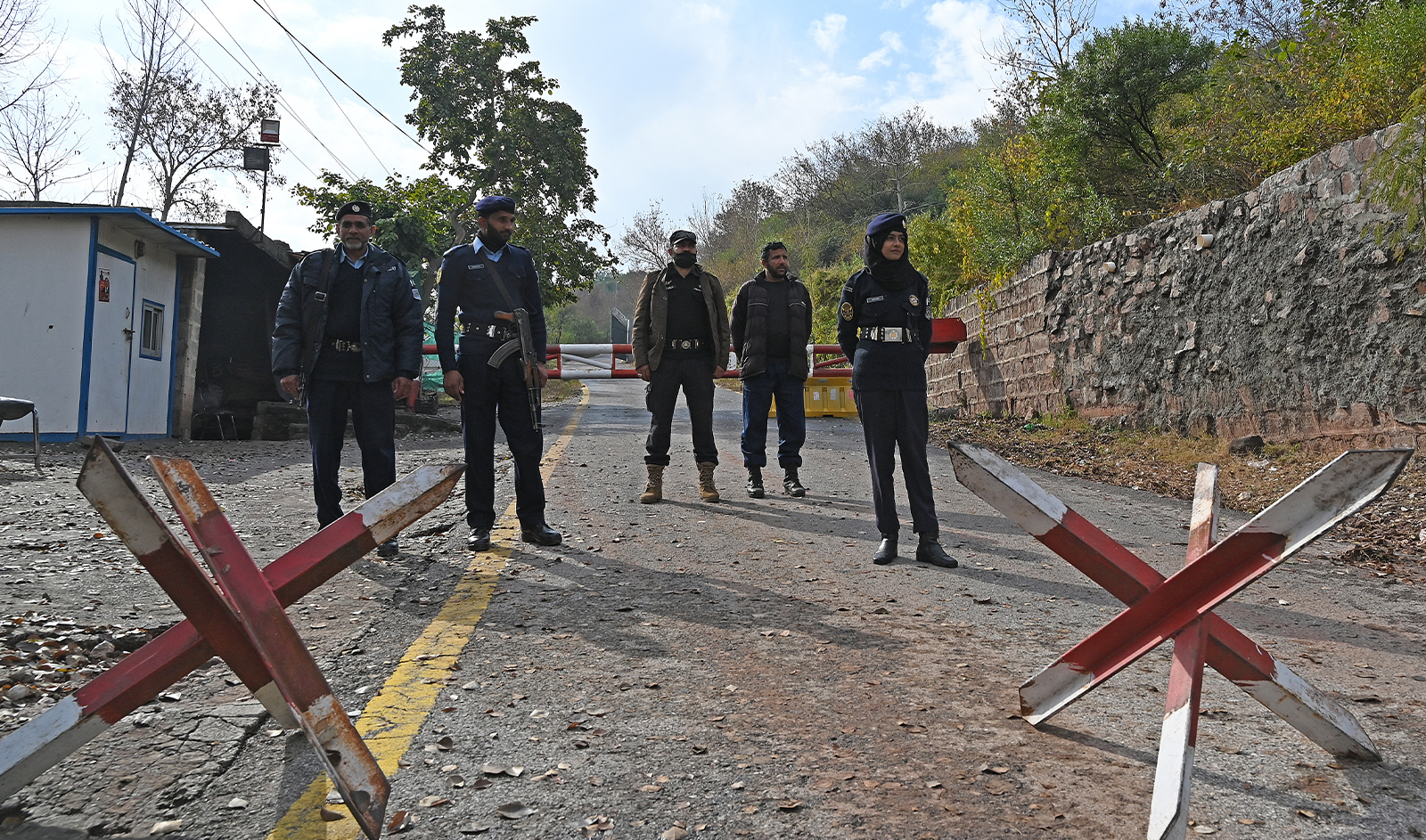 Police officers stand guard along a road outside the residence of Pakistan's former prime minister Imran Khan, in the Banigala area of Islamabad on February 1, 2024, where Khan's wife Bushra Bibi is serving her sentence after authorities declared it a "sub-jail." (AFP/File)