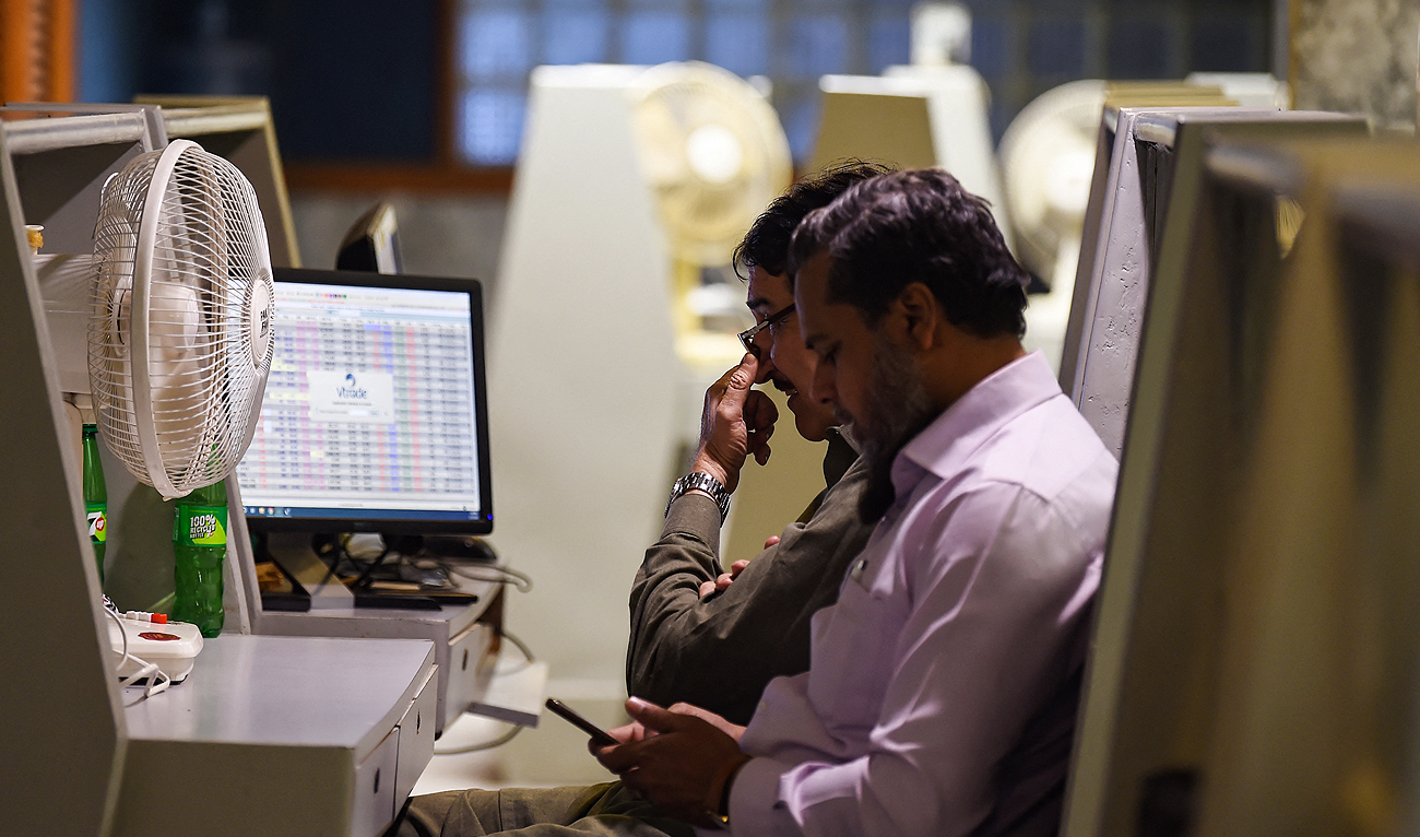 Stock brokers monitor share prices on a computer during a trading session at the Pakistan Stock Exchange (PSX) in Karachi on February 12, 2024. (AFP/File)