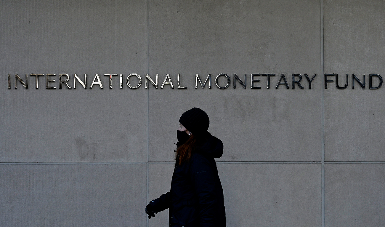 A woman walks past the International Monetary Fund headquarters in Washington, DC, on January 26, 2022. (AFP/File)