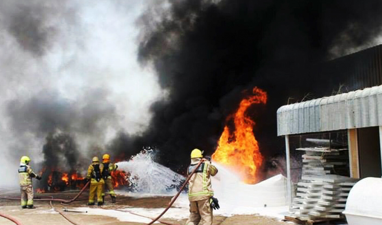Firefighters try to put out a fire that broke out in a fiberglass factory in the New industrial area in Ajman, UAE on February 24, 2024. (Photo courtesy: X/@ajmanpoliceghq)