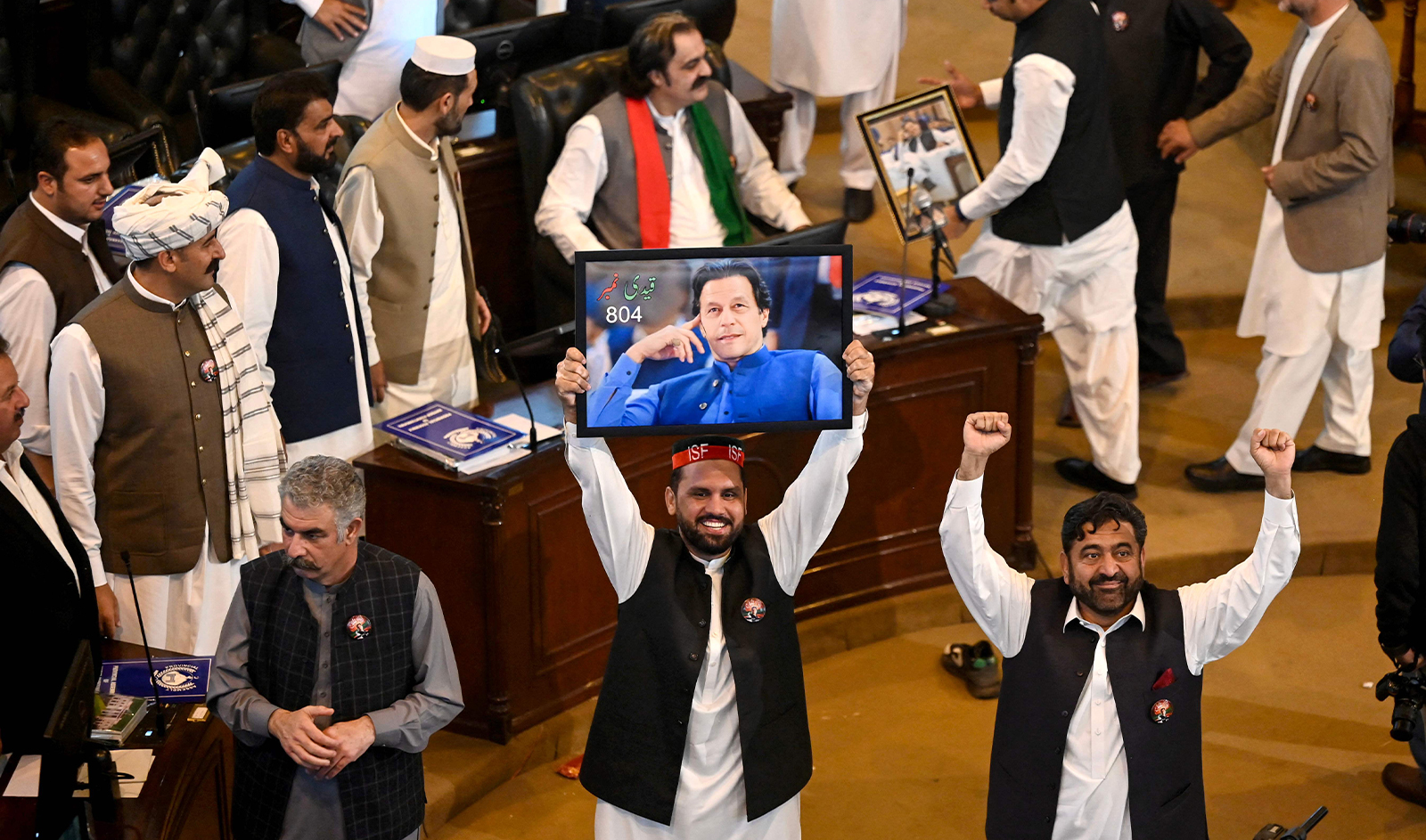 Members of jailed former prime minister Imran Khan's Pakistan Tehreek-e-Insaf (PTI) party and show a portrait of Khan during their oath taking ceremony following their election at the provincial legislature of Pakistan's Khyber Pakhtunkhwa (KP) Assembly in Peshawar on February 28, 2024. (AFP)