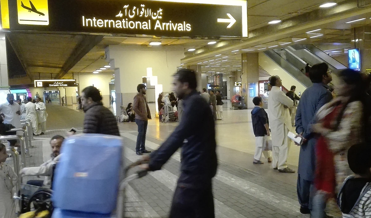 Passengers walk after their arrival at the Jinnah International Airport in Karachi on January 31, 2020. (AFP)