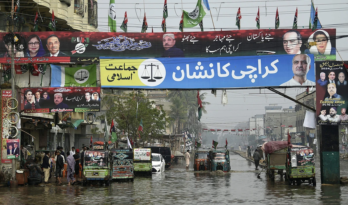 Election posters and banners of the Pakistan Peoples Party (PPP) and Jamaat-e-Islami party are seen across a flooded street in Karachi on February 4, 2024, ahead of the upcoming general elections. (AFP)