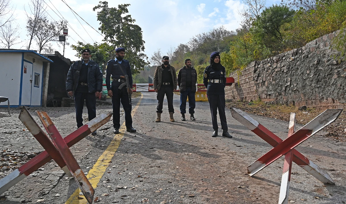 Police officers stand guard along a road outside the residence of Pakistan's former prime minister Imran Khan, in the Banigala area of Islamabad on February 1, 2024, where Khan's wife Bushra Bibi is serving her sentence after authorities declared it a "sub-jail." (AFP/File)