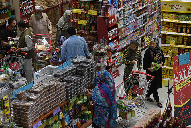 People buy grocery items at a store in Peshawar on April 5, 2021. (AFP/File)