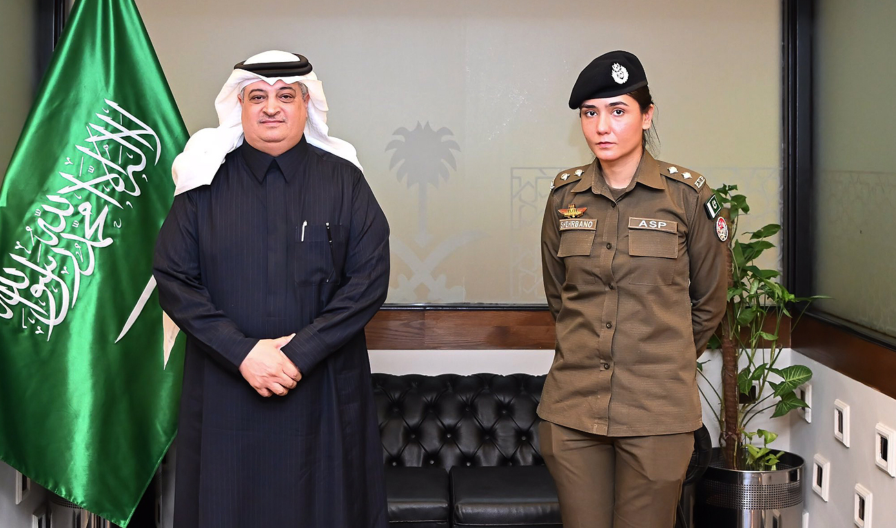 In this handout photo, taken and released by Embassy of Saudi Arabia, Saudi ambassador to Pakistan Nawaf bin Saeed Al-Malki gestures for a photo with Syeda Shehrbano Naqvi, an assistant superintendent with Punjab police, at the Saudi embassy in Islamabad on March 1, 2024. (Photo courtesy: X/@KSAembassyPK)