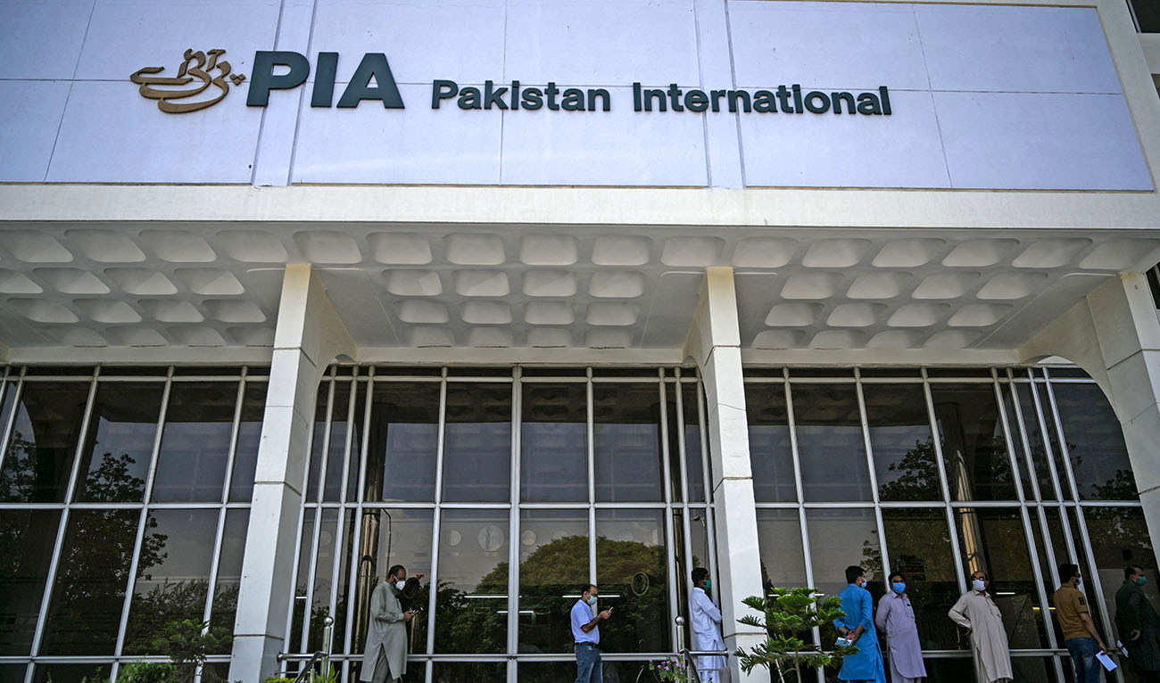People stand in queue as they wait their turn to buy flight tickets outside Pakistan International Airlines (PIA) office in Islamabad on July 1, 2020. (AFP/File)