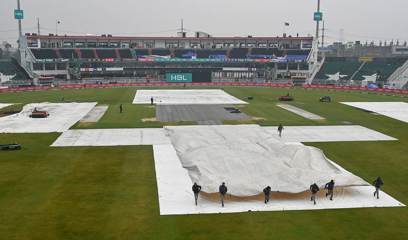 Ground staff covers the pitch as it rains and delays the start of the Pakistan Super League (PSL) Twenty20 cricket match between Peshawar Zalmi and Lahore Qalandars in the Rawalpindi Cricket stadium in Rawalpindi on March 2, 2024. (AFP)