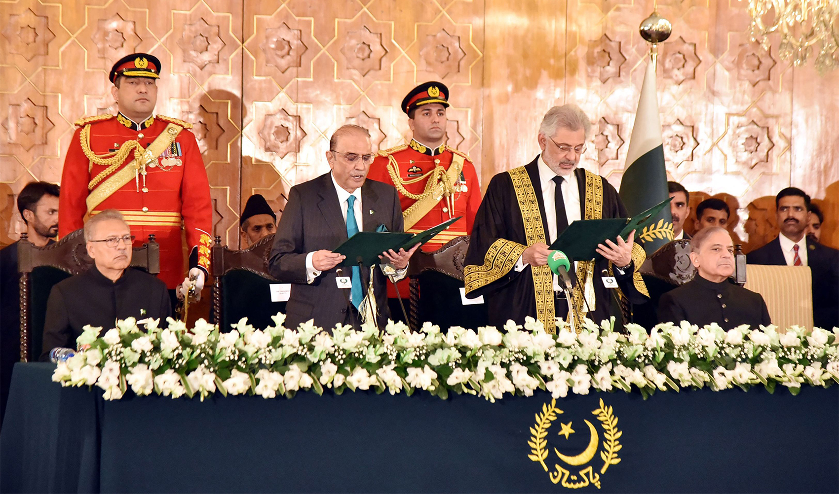 In this handout photograph taken and released by the Pakistan President House on March 10, 2024, Supreme Court Chief Justice Qazi Faez Isa (6R) administers oath to the newly sworn-in Pakistan’s President Asif Ali Zardari (5L) at the President House in Islamabad. (REUTERS via PID)