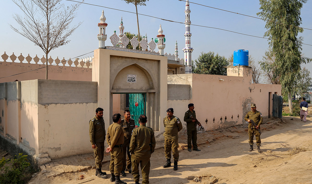 Police gather near the site where a man was killed after allegedly an angry mob stoned him to death at Khanewal district on February 13, 2022. (AFP/File)