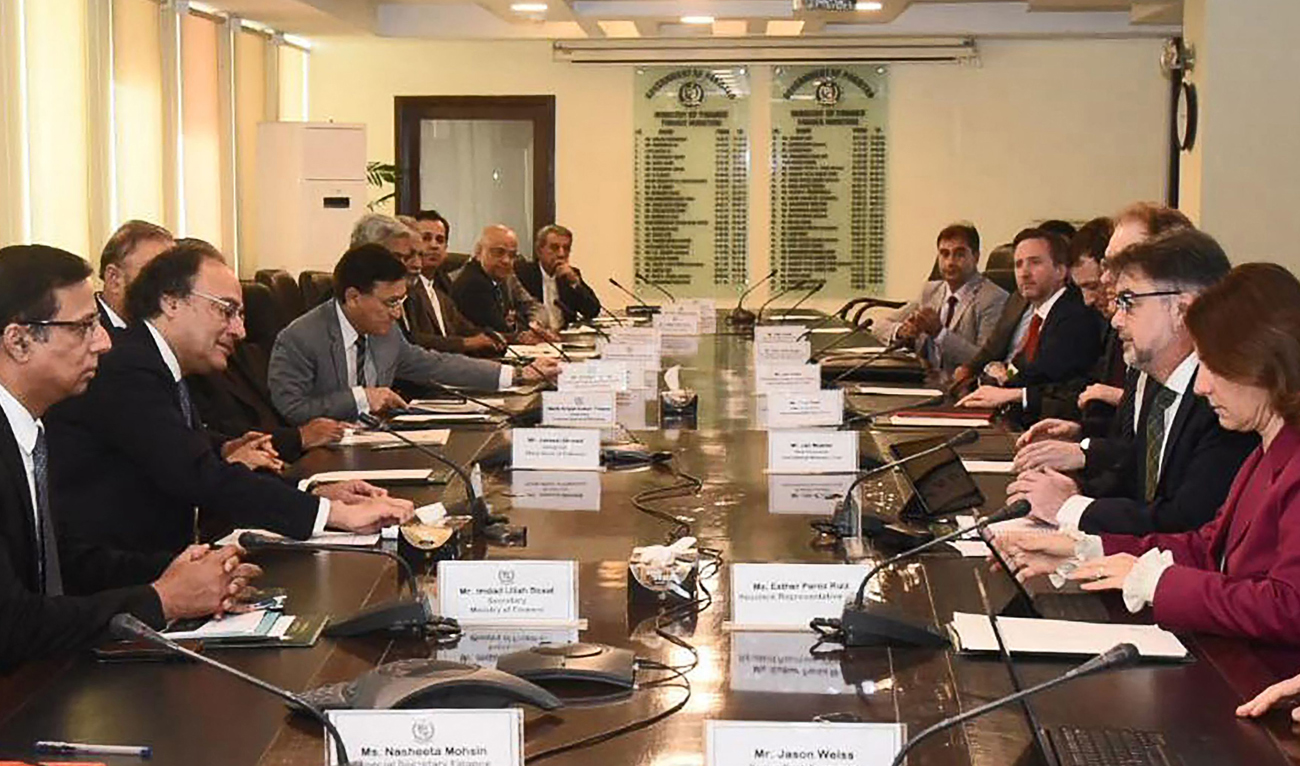 In this handout photograph released by Pakistan’s Press Information Department (PID) and taken on March 14, 2024, Pakistan’s Finance Minister Muhammad Aurangzeb (2L) speaks with International Monetary Fund (IMF) Mission Chief for Pakistan Nathan Porter (2R) during a meeting in Islamabad. (PID)