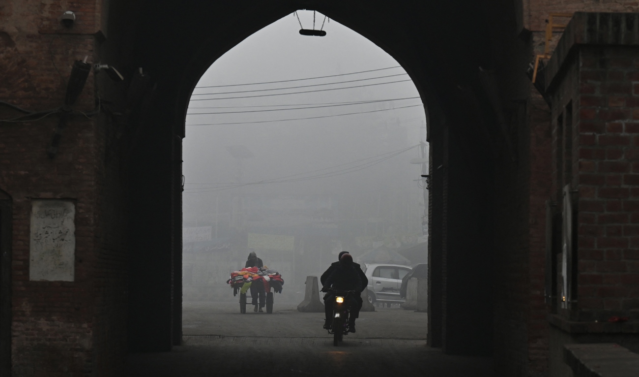A motorists rides under a gate amid heavy smog conditions in Lahore January 17, 2024. (AFP)