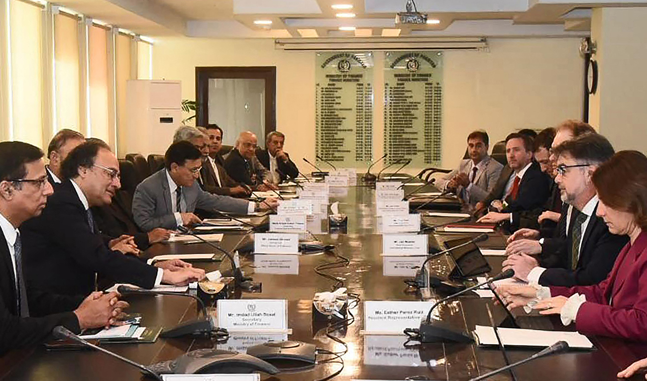 In this handout photograph released by Pakistan’s Press Information Department (PID) and taken on March 14, 2024, Pakistan’s Finance Minister Muhammad Aurangzeb (2L) speaks with International Monetary Fund (IMF) Mission Chief for Pakistan Nathan Porter (2R) during a meeting in Islamabad. (AFP)
