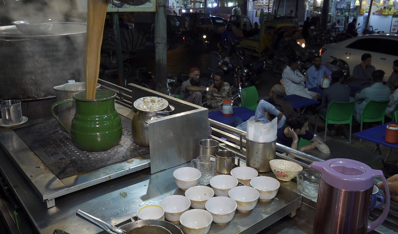 A worker pours tea cups for customers at a local cafe in Karachi on March 19, 2024. (AN Photo)