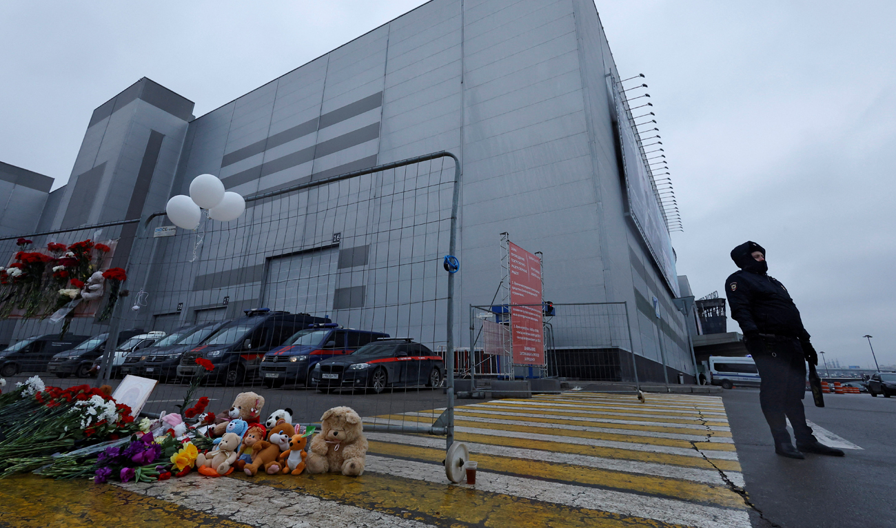 A police officer stands next to a makeshift memorial to the victims of a shooting attack at the Crocus City Hall concert venue in the Moscow Region, Russia, March 23, 2024. (REUTERS)