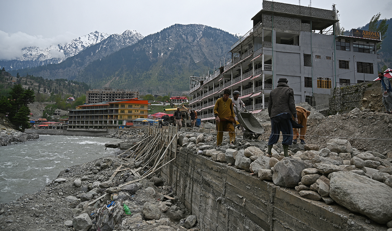 In this picture taken on May 4, 2023, workers build a protection wall beside the banks of river Swat at the tourist hill station of Kalam in Swat valley in Khyber Pakhtunkhwa province. (AFP/File)