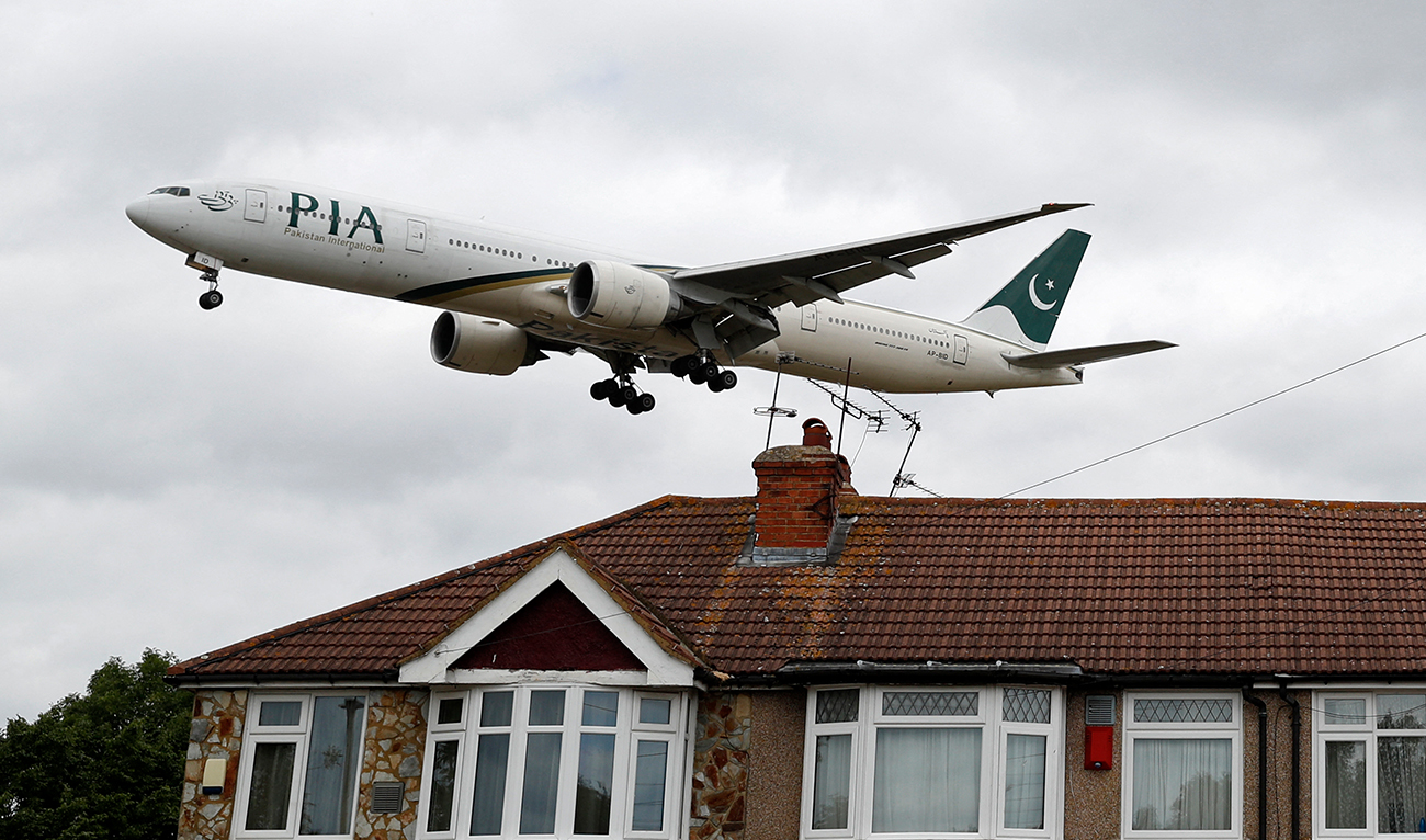A Pakistan International Airlines Boeing 777 comes in over houses, to land at Heathrow airport in west London as the UK government's planned 14-day quarantine for international arrivals to limit the spread of Covid-19 starts on June 8, 2020. (AFP/File)
