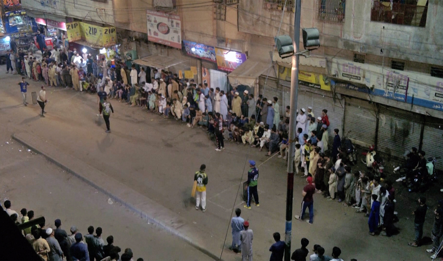 People play street cricket after iftar in Karachi, Pakistan on March 28, 2024. (REUTERS)