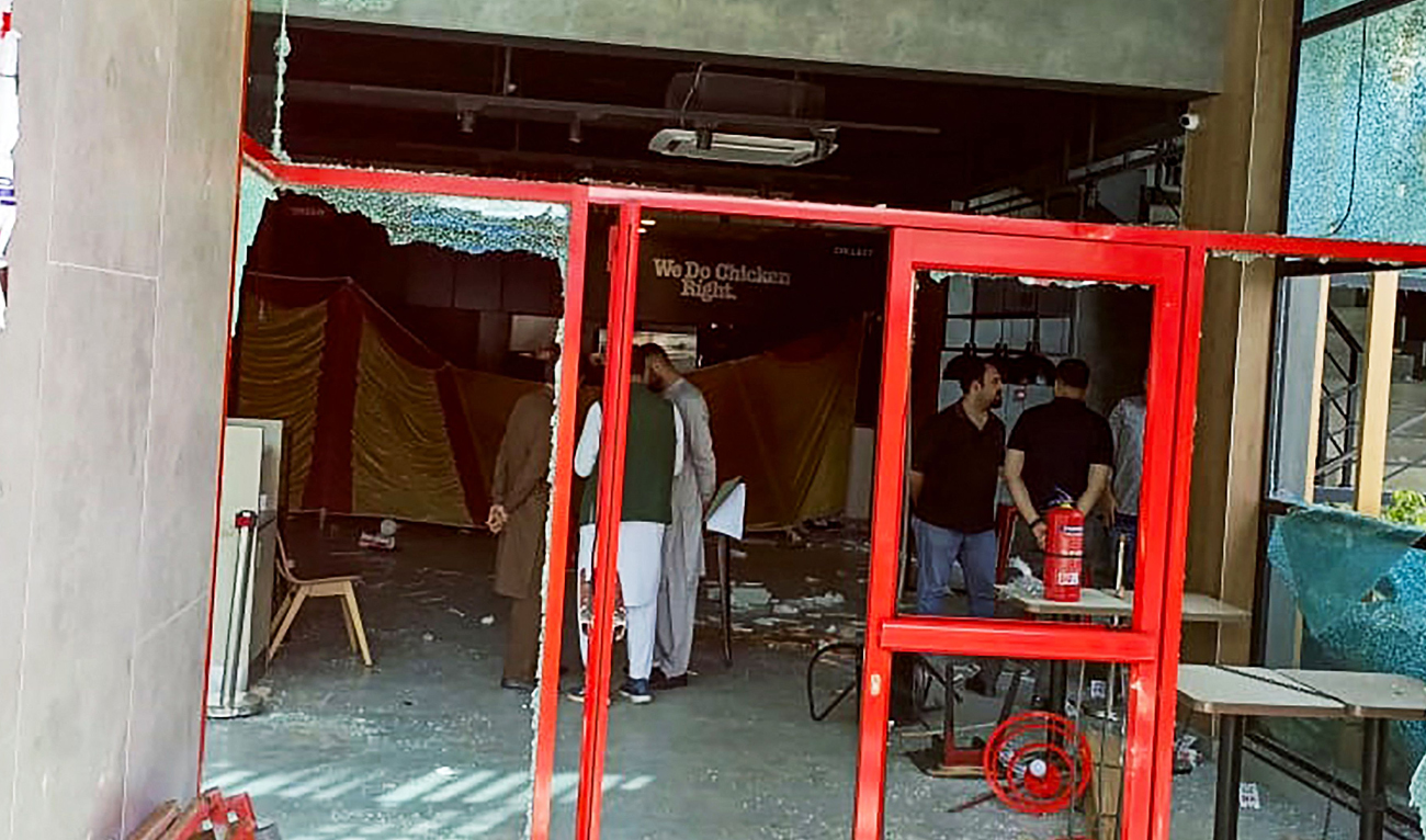 Security personnel inspect the damaged restaurant of the American fast food chain KFC, set on fire by pro-Palestinian protesters demonstrating against Israel in the northeastern town of Mirpur, Azad Kashmir on March 30, 2024. (AFP)