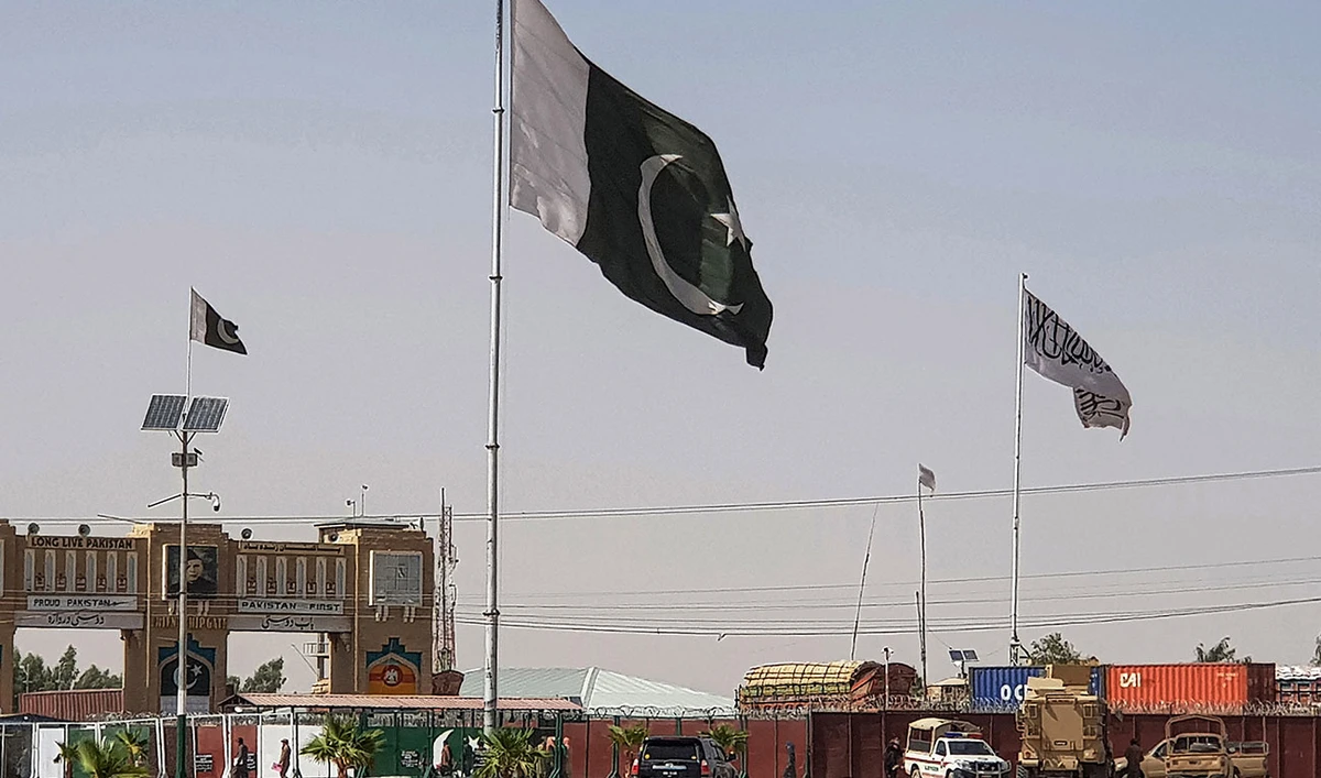 Pakistani flags (C) and Taliban flag (R) flutter on their respective border sides as seen from the Pakistan-Afghanistan border crossing point in Chaman on August 18, 2021. (AFP/File)