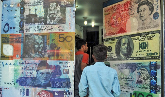 Pakistani customers enter a foreign currency exchange shop in Karachi, Pakistan, on October 14, 2010. (AFP/File)