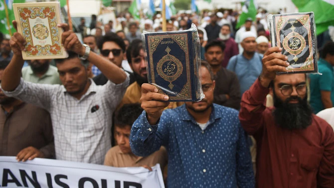 In this file photo, taken on July 5, 2023, supporters of Pakistan’s Jamaat-e-Islami party hold copies of the Qur’an during a demonstration in Karachi against Qur’an burning. (AFP/File)
