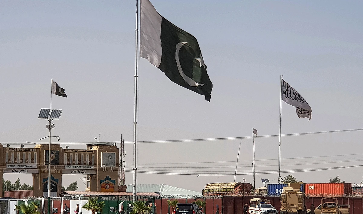 Pakistani flags (C) and Taliban flag (R) flutter on their respective border sides as seen from the Pakistan-Afghanistan border crossing point in Chaman on August 18, 2021. (AFP)