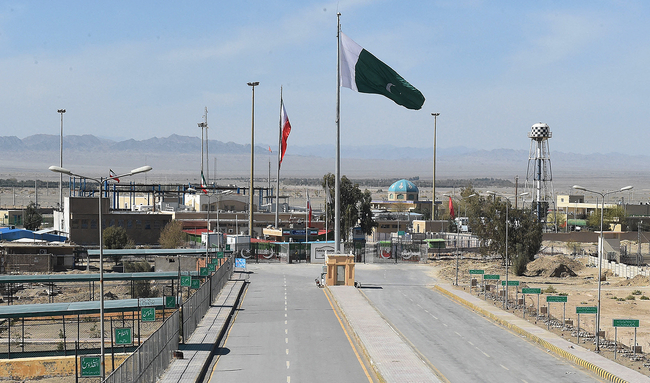 In this file photo, taken on February 25, 2020, Pakistani and Iranian flags flutter on the closed Pakistan-Iran border in Taftan. (AFP/File)