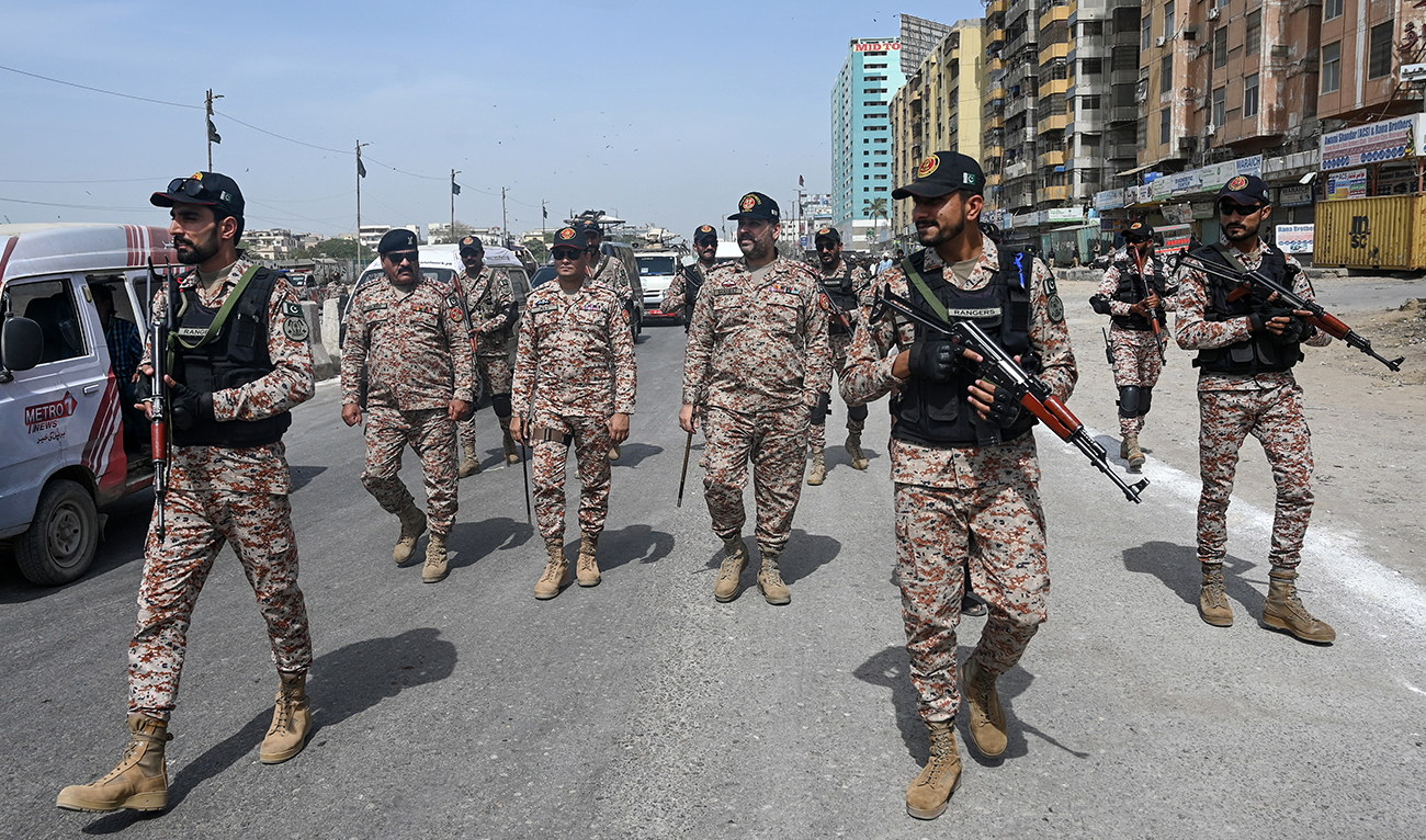 Security personnel patrol along a street during a procession to commemorate the martyrdom of Imam Ali, the cousin and son-in-law of Prophet Mohammed, during the holy month of Ramadan in Karachi on April 1, 2024. (AFP/File)