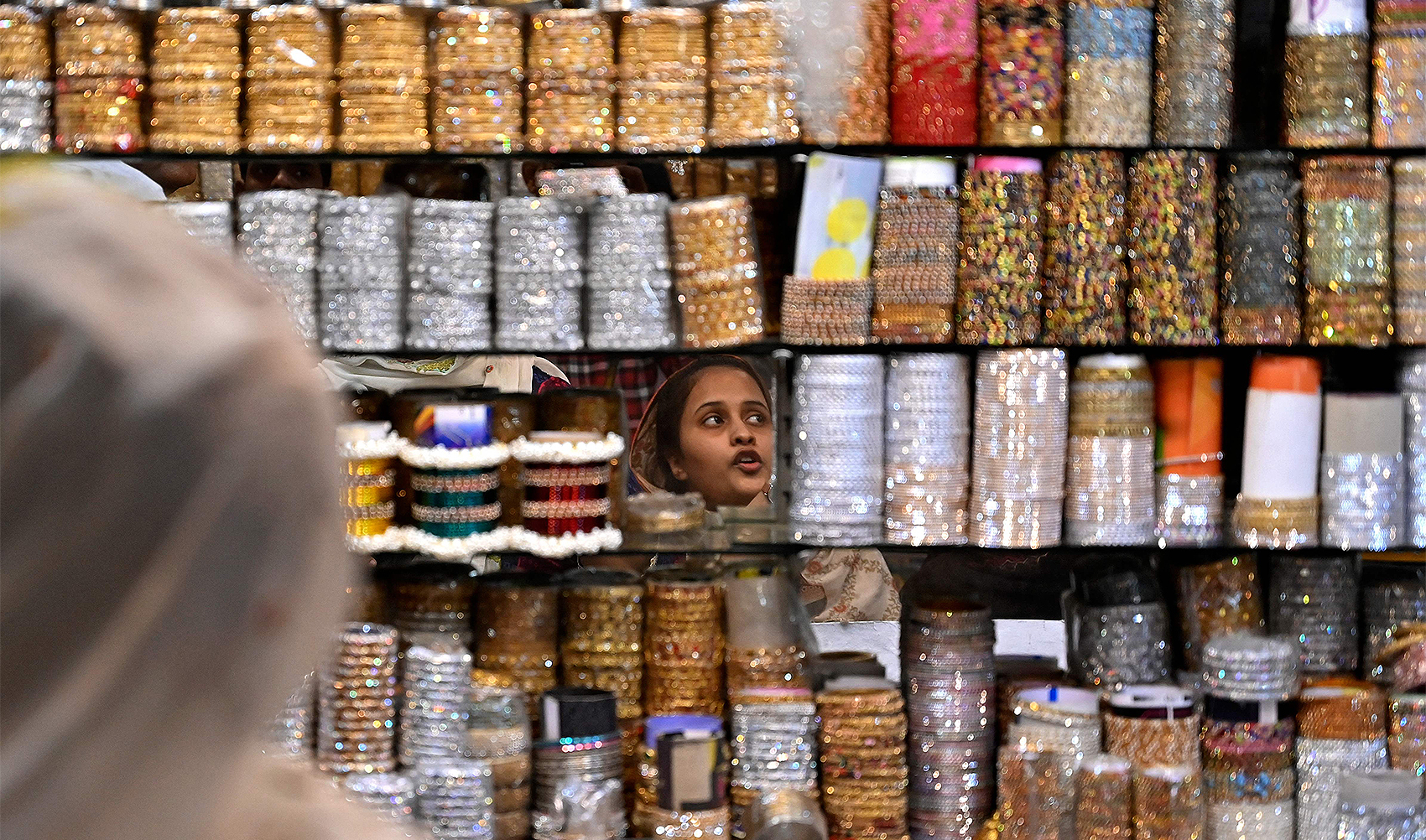 In this picture taken on March 31, 2024, a customer looks at bangles displayed in a shop in Hyderabad. (AFP)