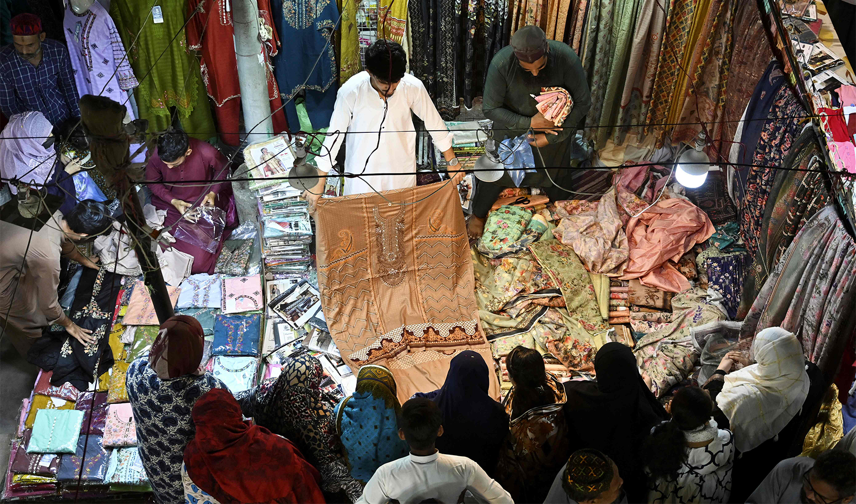 People shop clothes at a market in Karachi on April 5, 2024, ahead of Eid al-Fitr celebrations which marks the end of the Muslim holy month of Ramadan. (AFP)