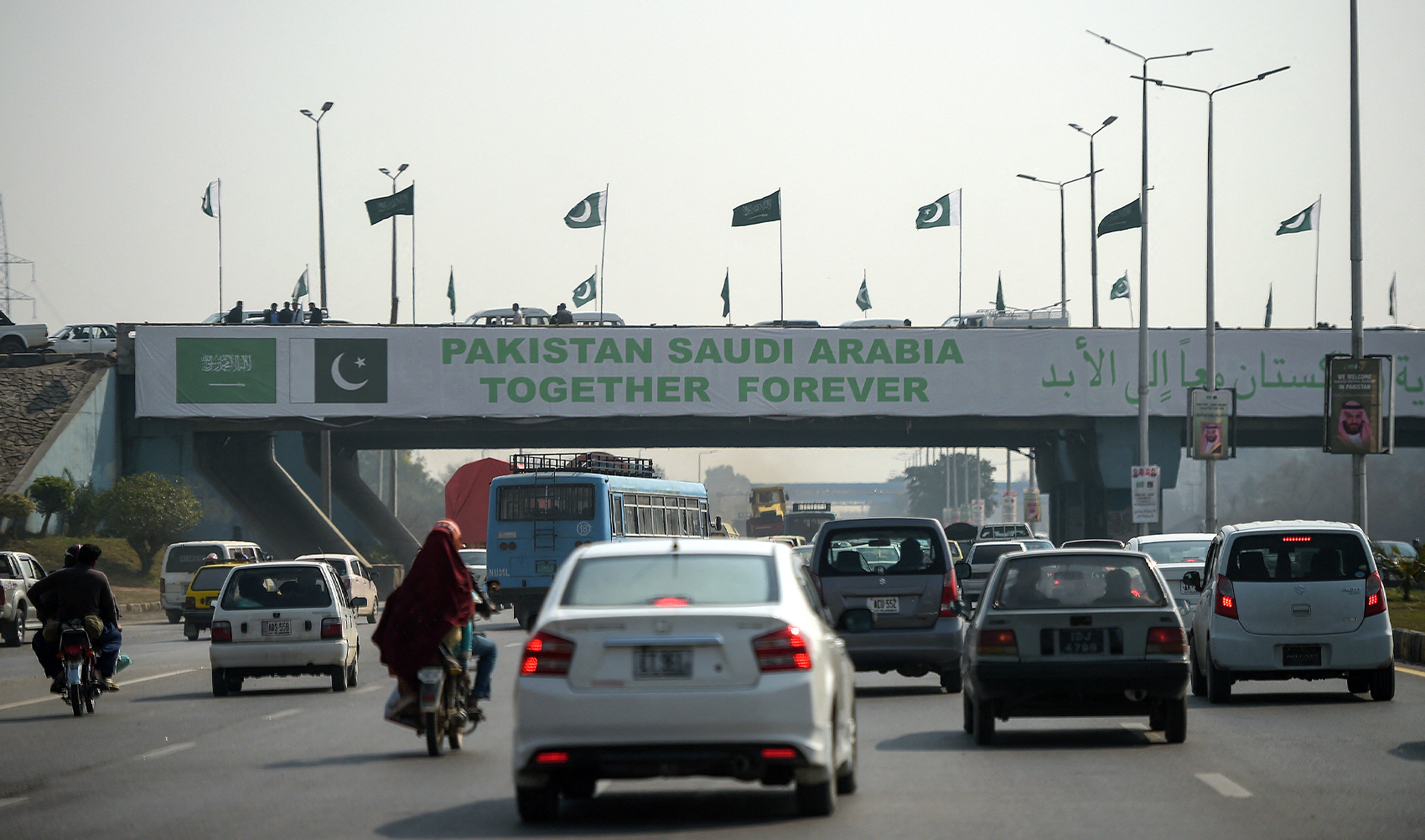 Pakistani commuters drive their vehicles under a banner welcoming Saudi Arabian Crown Prince Mohammed bin Salman displayed on a bridge, ahead of his arrival, in Islamabad on February 15, 2019. (AFP/File)