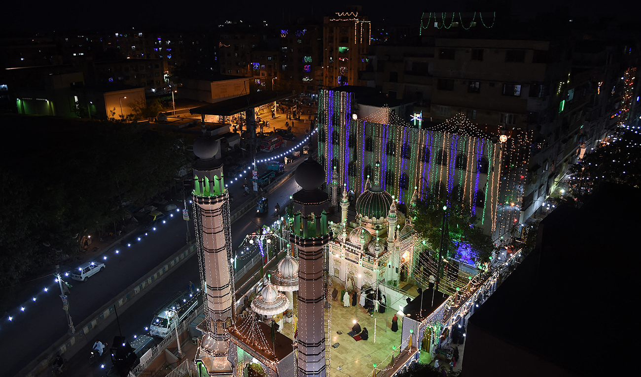 Pakistani women gather in front of a mosque decorated with lights in Karachi on January 3, 2015, ahead of celebration for the birthday of Prophet Mohammed. (AFP/File)