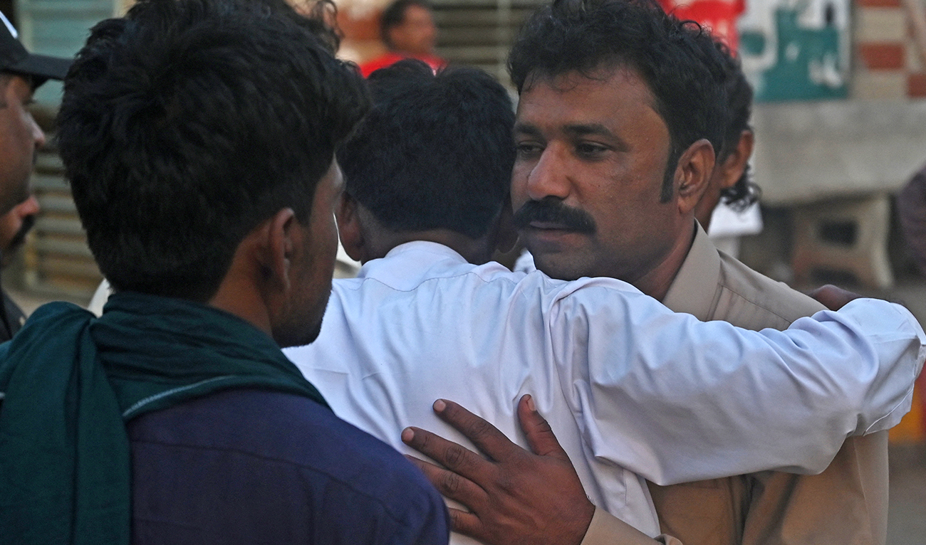 Relatives of religious pilgrims, who died in a truck accident, mourn in Karachi on April 11, 2024. (AFP)