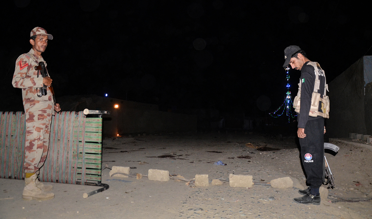 A Pakistani security personnel (L)and a policeman stand guard at the site of a suicide attack, outside a Sufi shrine in Jhal Magsi district in Balochistan province, on October 5, 2017. (AFP/File)
