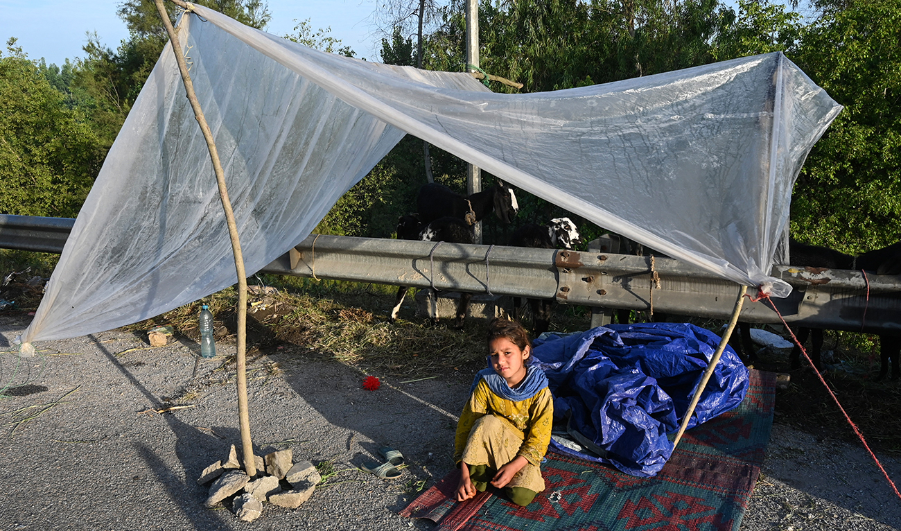 A displaced girl waits for assistance in her tent at a makeshift camp after fleeing from her flood hit home following heavy rains in Charsadda district of Khyber Pakhtunkhwa province on April 17, 2024. (AFP)
