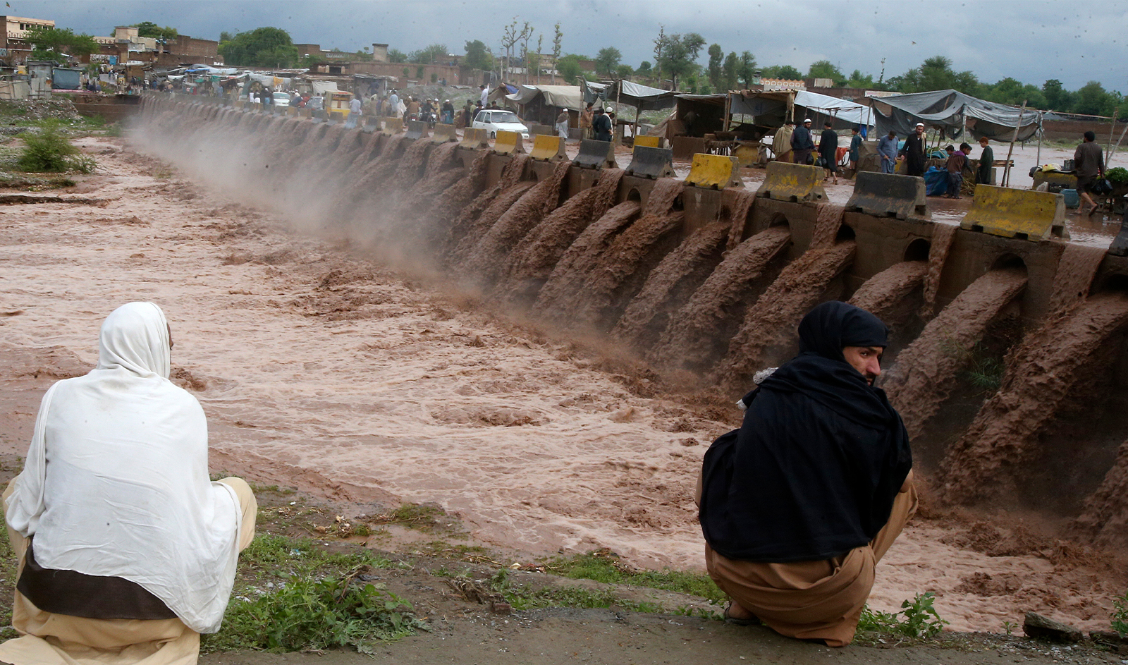 People looks a stream, which is overflowing following heavy rains, on the outskirts of Peshawar, Pakistan, on April 15, 2024. (AP)