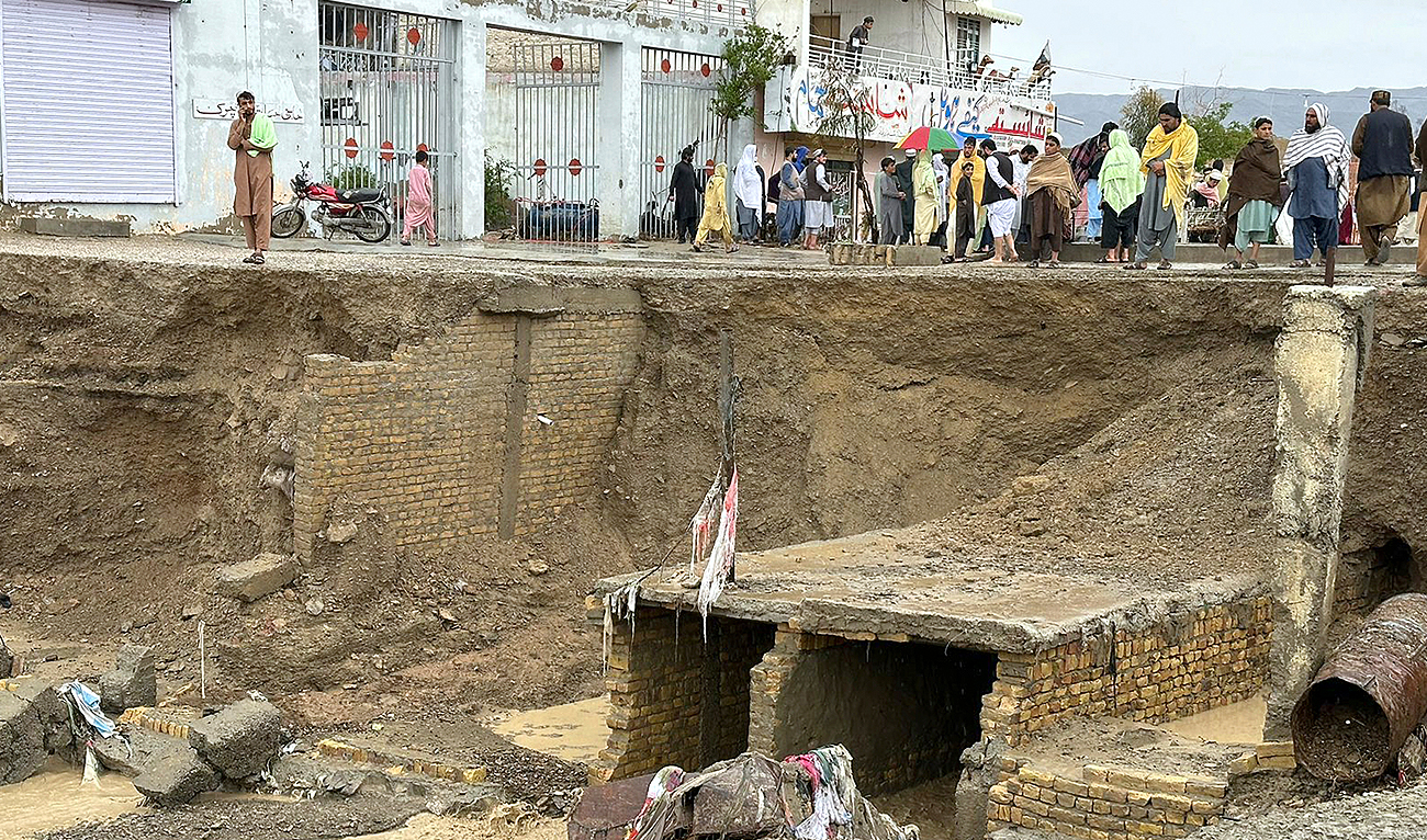 People look a damage portion washed away by floodwater following heavy rains, in Chaman, Pakistan, Thursday, April 18 2024. (AP)