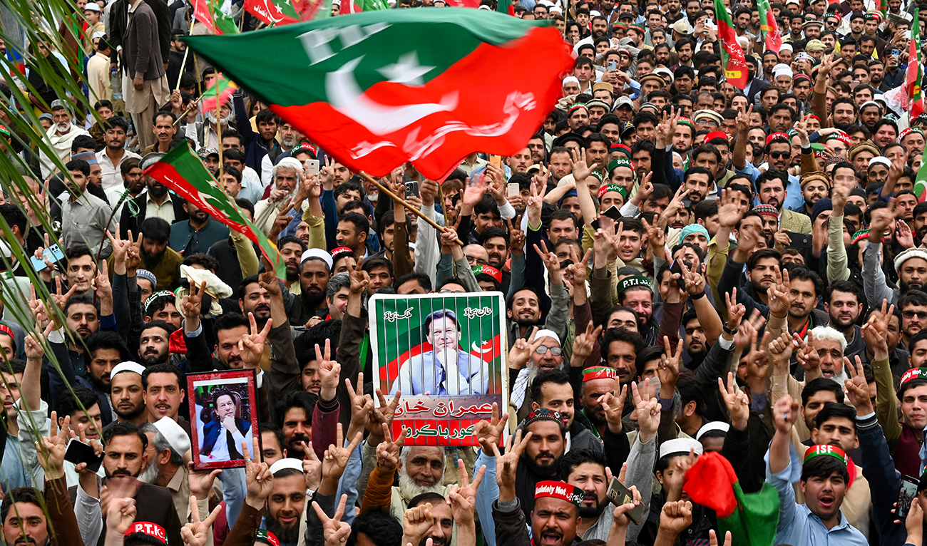 Pakistan Tehreek-e-Insaf (PTI) party supporters hold portraits of Pakistan's former prime minister Imran Khan, as they protest against the alleged skewing in Pakistan's national election, in Peshawar on March 10, 2024. (AFP/File)