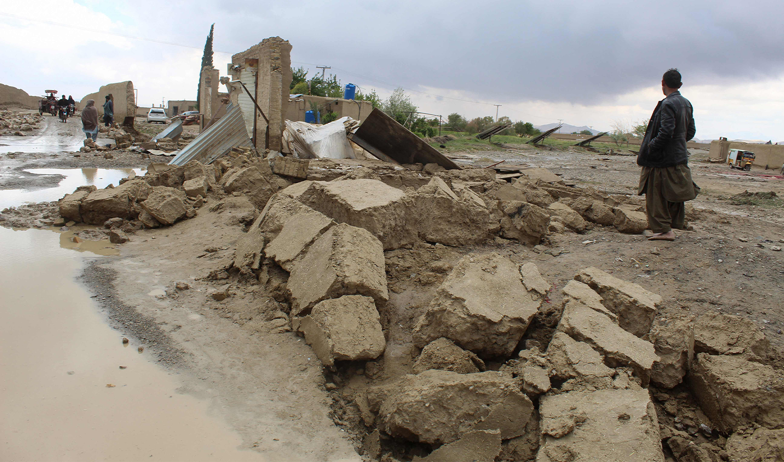 Residents gather beside a damaged house after heavy rains on the outskirts of Chaman in Balochistan province on April 19, 2024. (AFP/File)