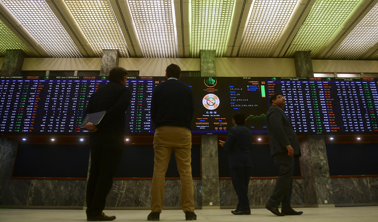 Brokers monitor an index board showing latest share prices at the Pakistan Stock Exchange in Karachi on January 26, 2023. (AFP/File)