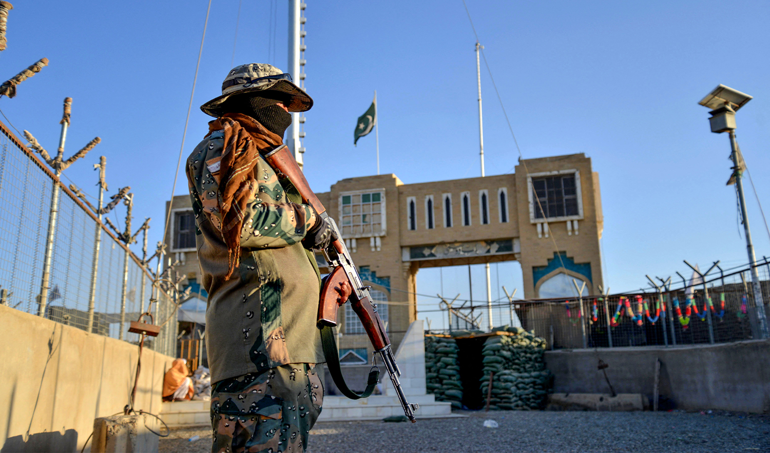 An Afghan security personnel stands guard at a fenced corridor of the Afghanistan-Pakistan border in Spin Boldak district, Kandahar province on December 3, 2023. (AFP/File)
