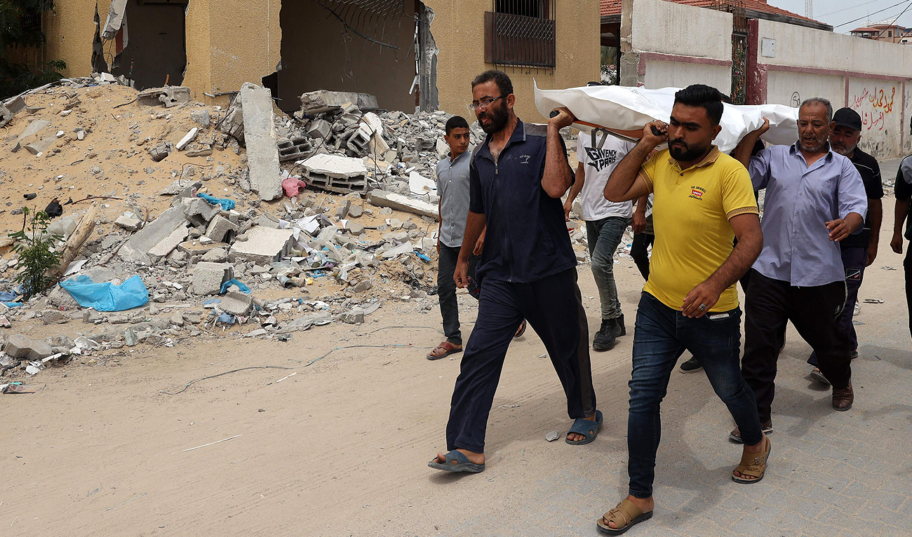 People carry away a body after identifying it among corpses unearthed from a mass grave found in the Nasser Medical Complex in the southern Gaza Strip on April 25, 2024, amid the ongoing conflict between Israel and Hamas. (AFP)