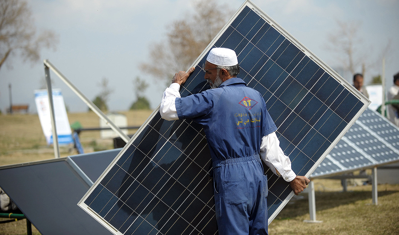 In this file photo, taken on March 10, 2012, a Pakistani company employee arranges a solar panel during a marketing demonstration in a park in Islamabad. (AFP/File)